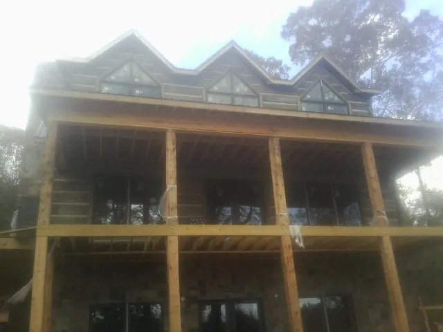 Dormers and porch framing on a large log home under construction in Galveston