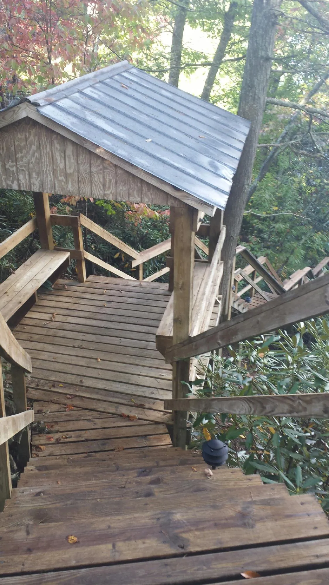 Metal roofed shelter over wooden steps on a wooded walkway — Skylight Repair & Installation work by our crew in Galveston