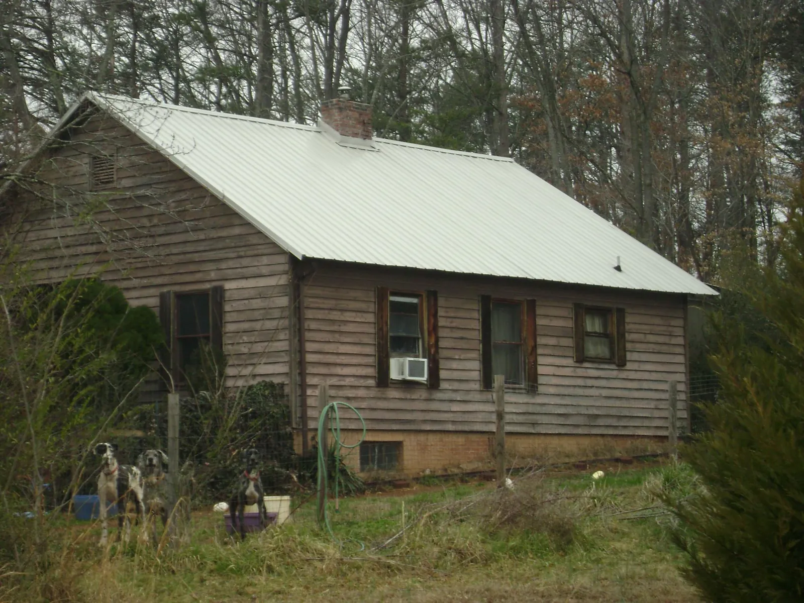 White metal roof on an old wood sided farmhouse, from a Metal Roof Installation job in Galveston